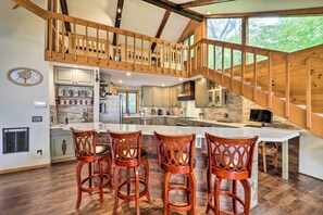 A spacious kitchen with a large island, wooden staircase, and a view of greenery outside. - Ski, Hike & Relax: Beech Mtn Gem w/ Sweeping Views (Banner Elk)