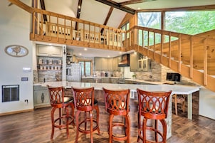 Cocina amplia con una isla grande, escalera de madera y vistas al exterior.