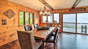 Un intérieur en bois avec une grande table à manger, des chaises et un lustre.