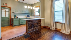A kitchen with a wooden island, green cabinets, and a ceiling fan. - Cozy Indianapolis Vacation Rental w/ Micro Farm! (Indianapolis)