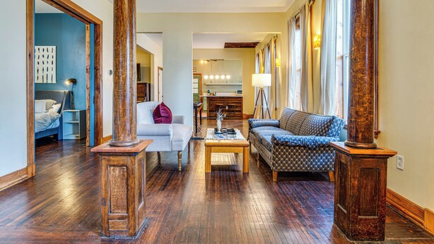 A spacious living room with hardwood floors, a sofa, a coffee table, and a fireplace. - Cozy Indianapolis Vacation Rental w/ Micro Farm! (Indianapolis)