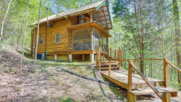 Eine Holzhütte mit Balkon, umgeben von Bäumen.