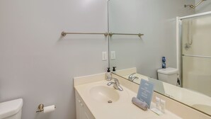 A bathroom with a white sink, a mirror, a towel rack, and a toilet.