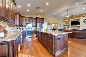 A spacious kitchen with dark wooden cabinets, stainless steel appliances, and a large island. - Outdoor Oasis w/ Private Pool! Casa Grande Escape (Casa Grande)