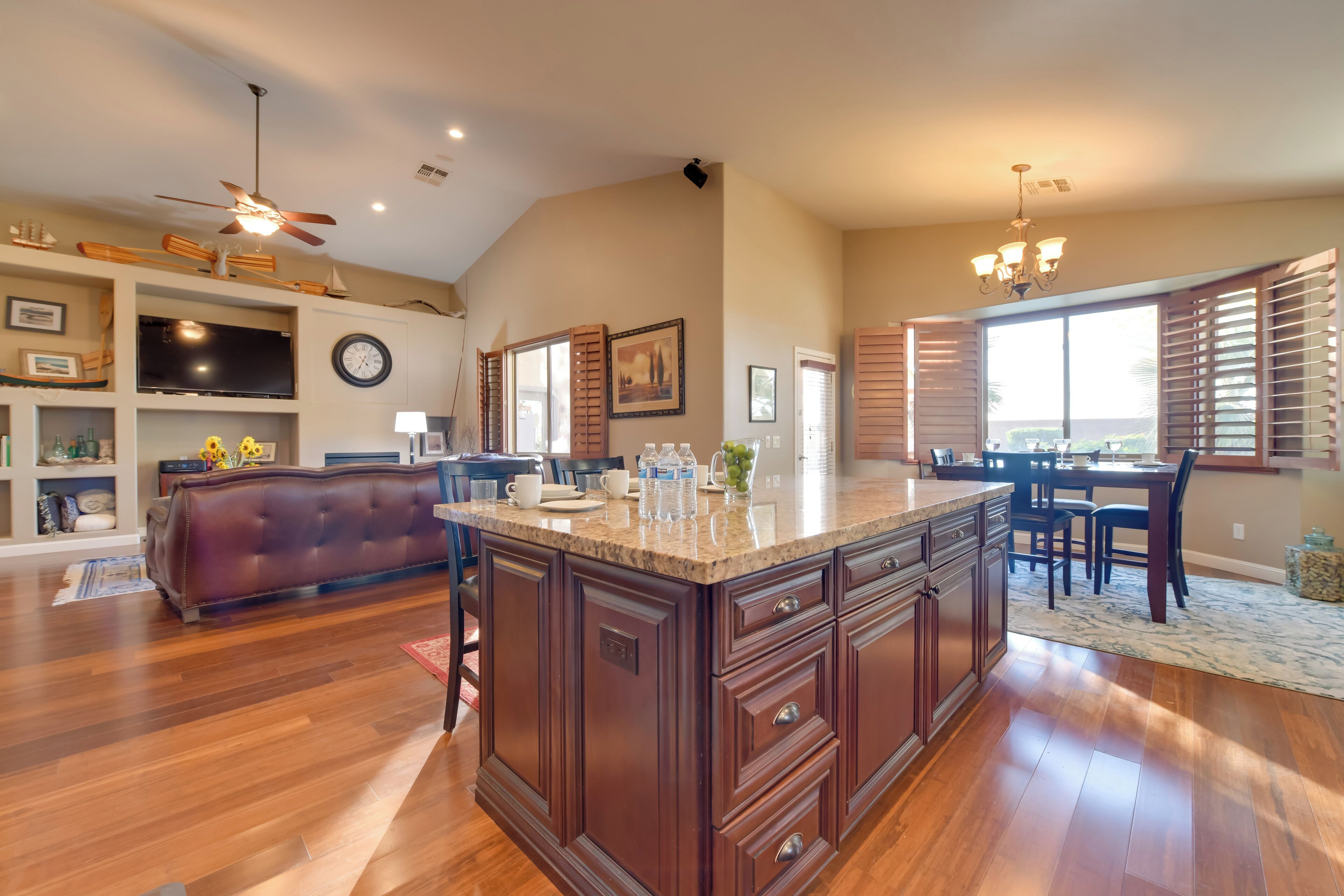 Una cocina amplia con una isla grande, armarios de madera y un comedor con mesa y sillas.