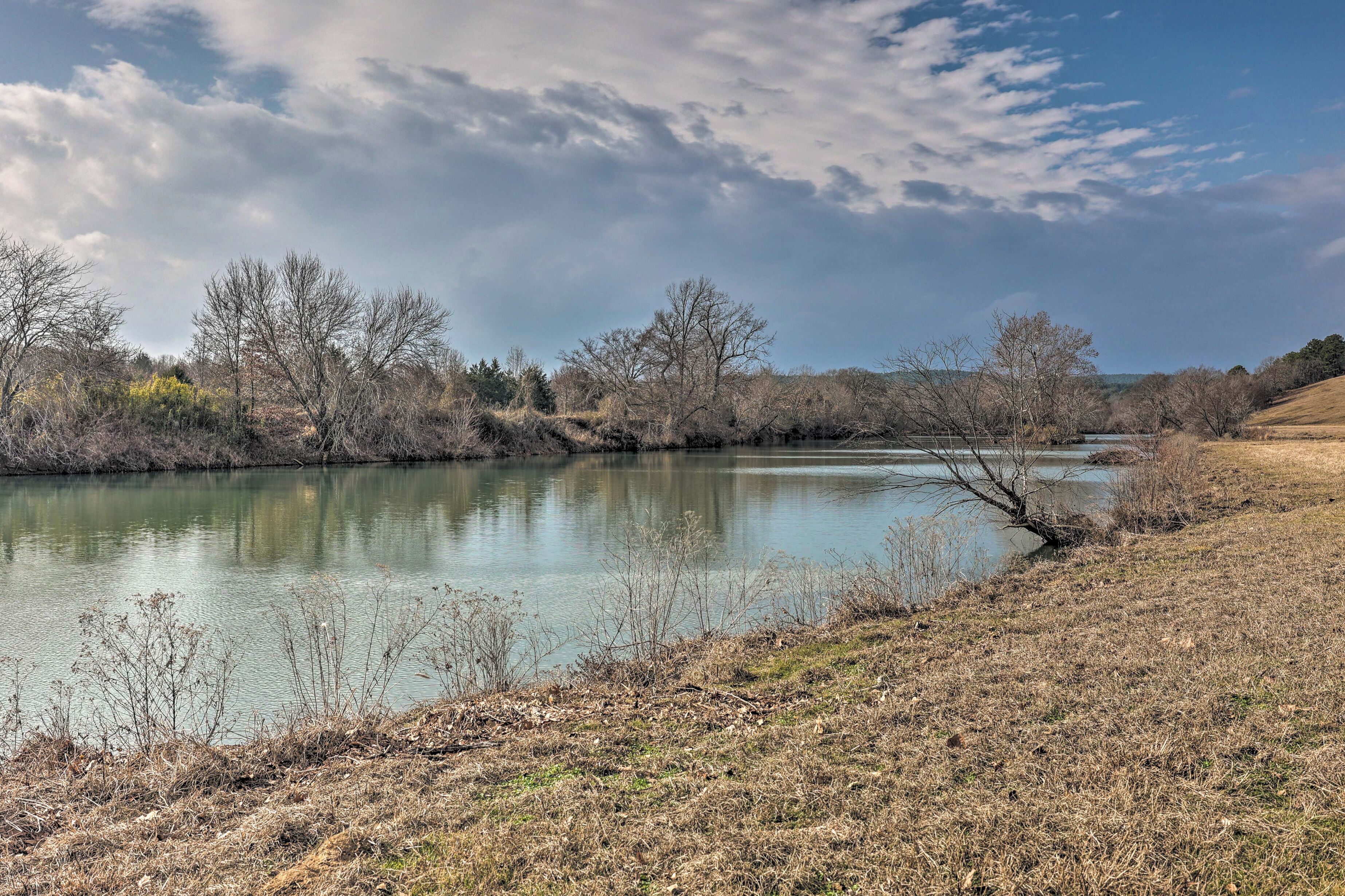 A river with trees and a grassy bank.