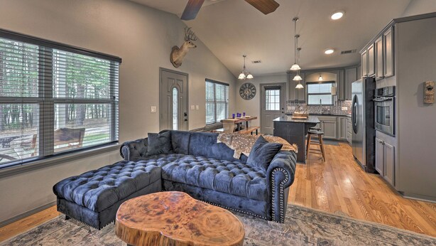 A spacious living area with a sectional sofa, a wooden coffee table, and a ceiling fan. - Hogden Home Near the Black Fork River & Trails! (Hodgen)