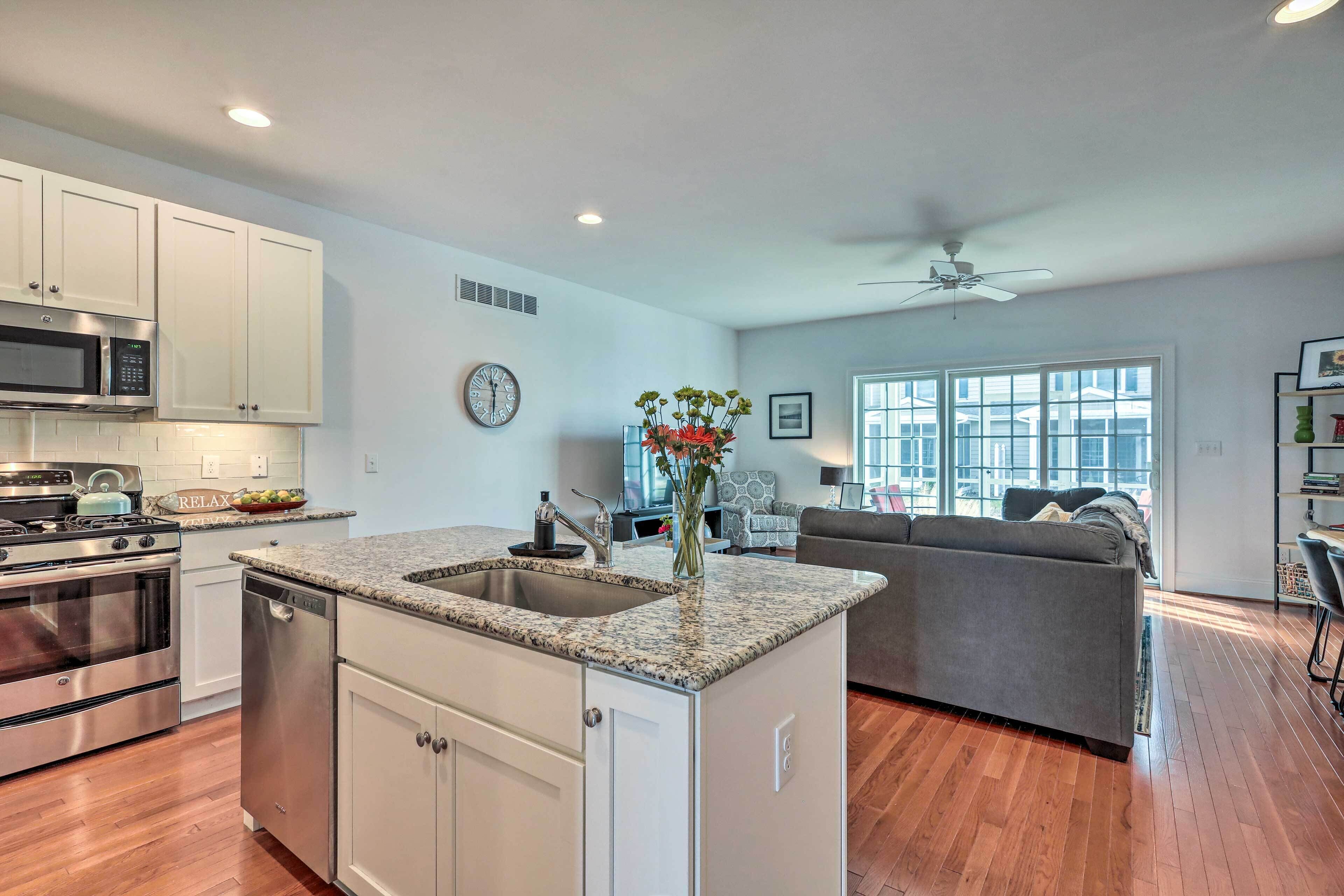 A modern kitchen with stainless steel appliances, a granite countertop, and a built-in sink.