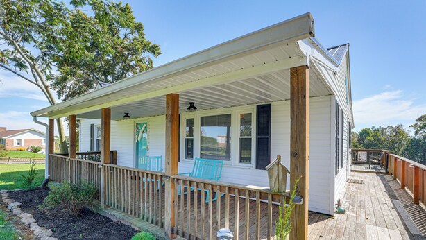 A covered porch with wooden railings, a welcome sign, and outdoor seating. - Beautiful Views & Gas Grill: Sparta Getaway! (Sparta)