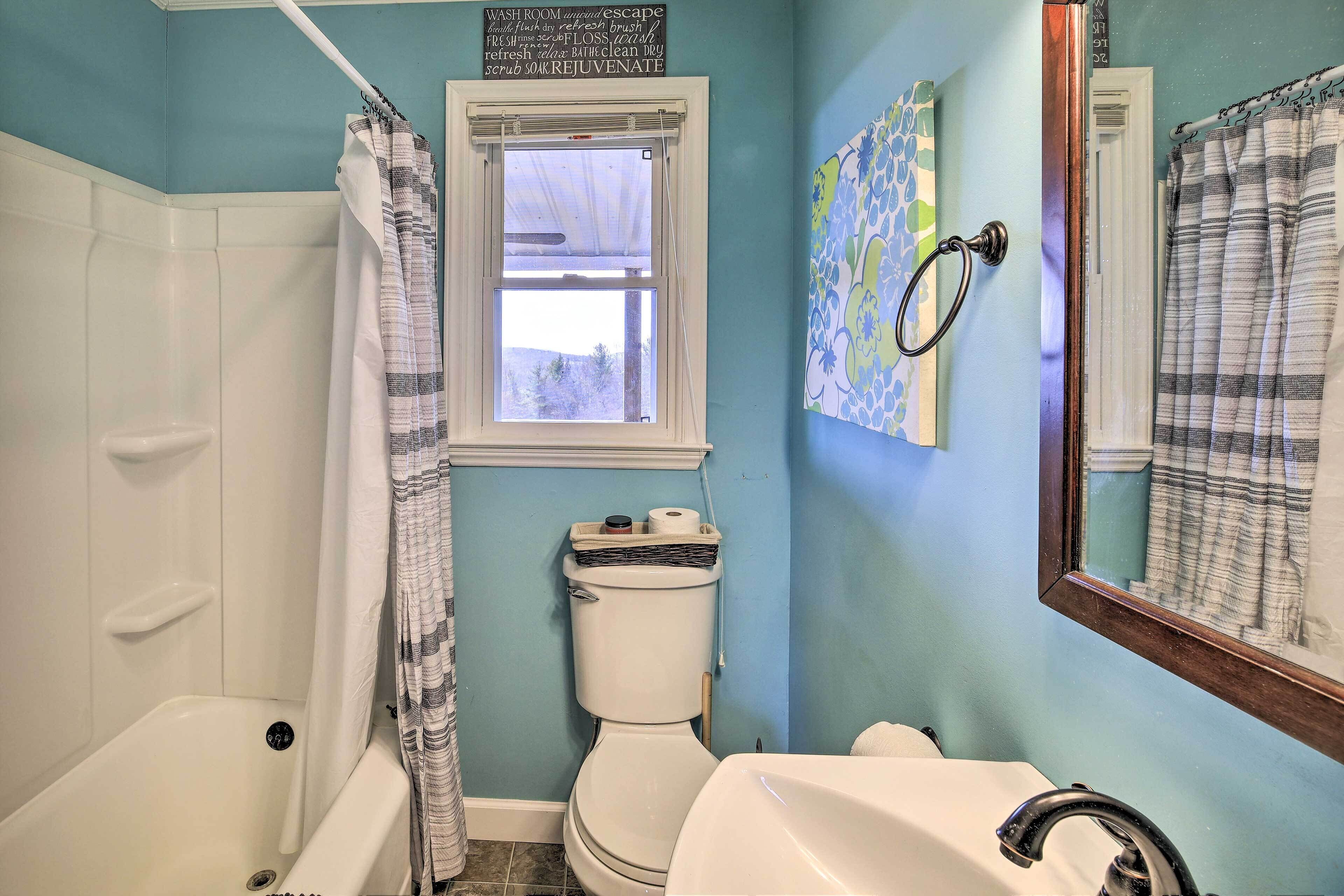 A bathroom with a bathtub, toilet, and sink.