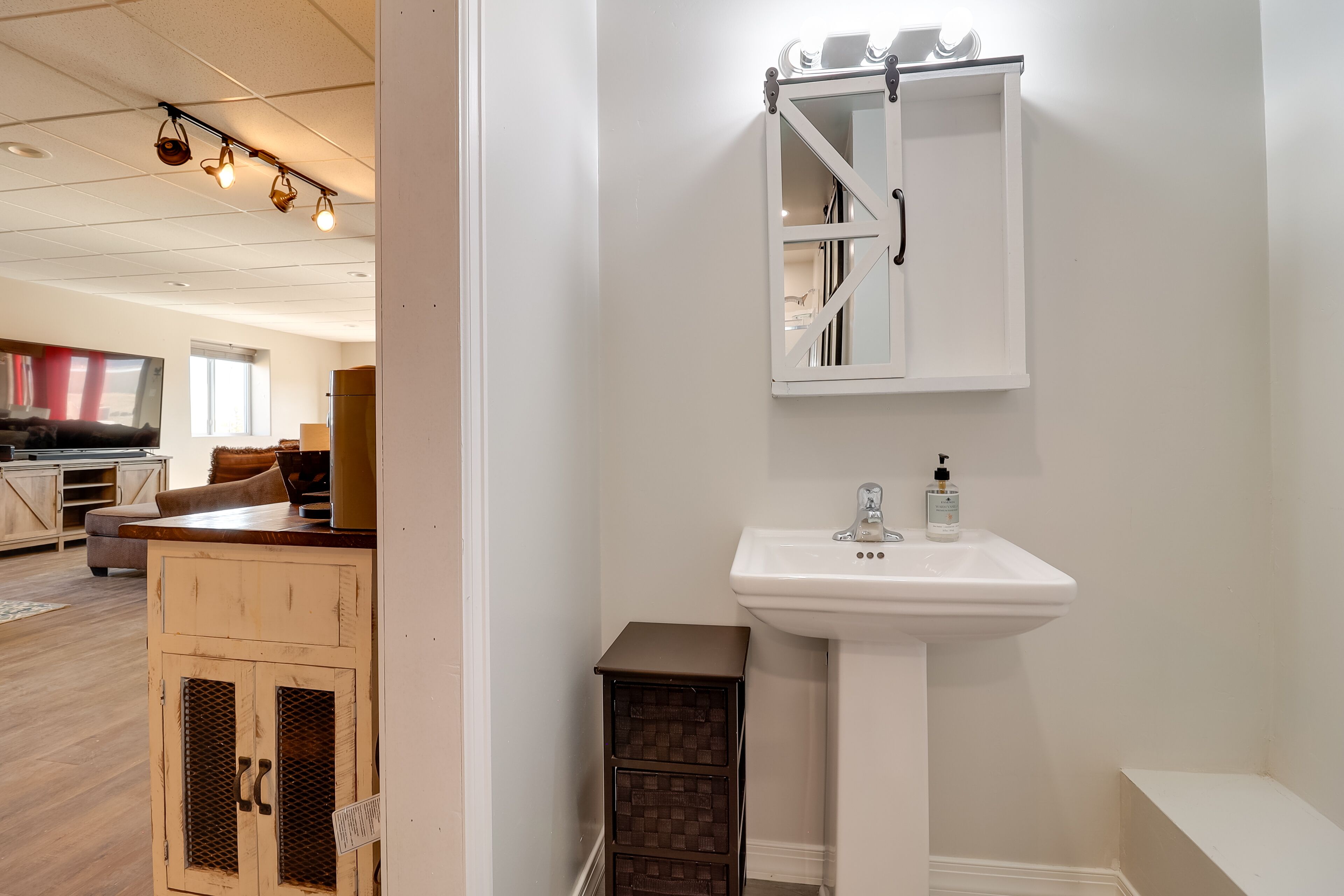 A bathroom with a white sink, a mirror, and a cabinet.