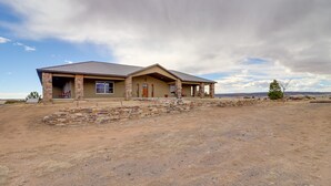 A two-story house with a stone facade, a flat roof, and a front porch. - Beulah Valley Vacation Rental With Private Patio (Beulah)