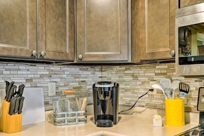 A kitchen with wooden cabinets, a coffee maker, a knife block, a spice rack, and a toaster. - Johnson City Vacation Rental: 1 Block to Etsu (Johnson City)