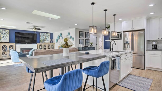 A modern kitchen with white cabinets, stainless steel appliances, and blue bar stools. - Pool, Jacuzzi & Fire Pit: Scottsdale Escape! (Scottsdale)