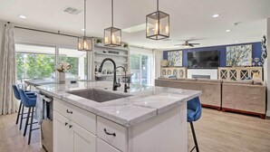 A modern kitchen with a marble island, pendant lights, and a large window. - Pool, Jacuzzi & Fire Pit: Scottsdale Escape! (Scottsdale)
