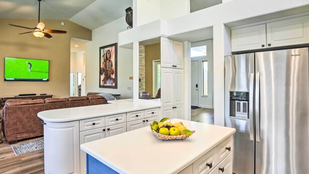 A modern kitchen with white cabinetry, a stainless steel refrigerator, and a fruit bowl on the island. - Pool, BBQ & Fire Pit: Family Home in Cave Creek (Cave Creek)