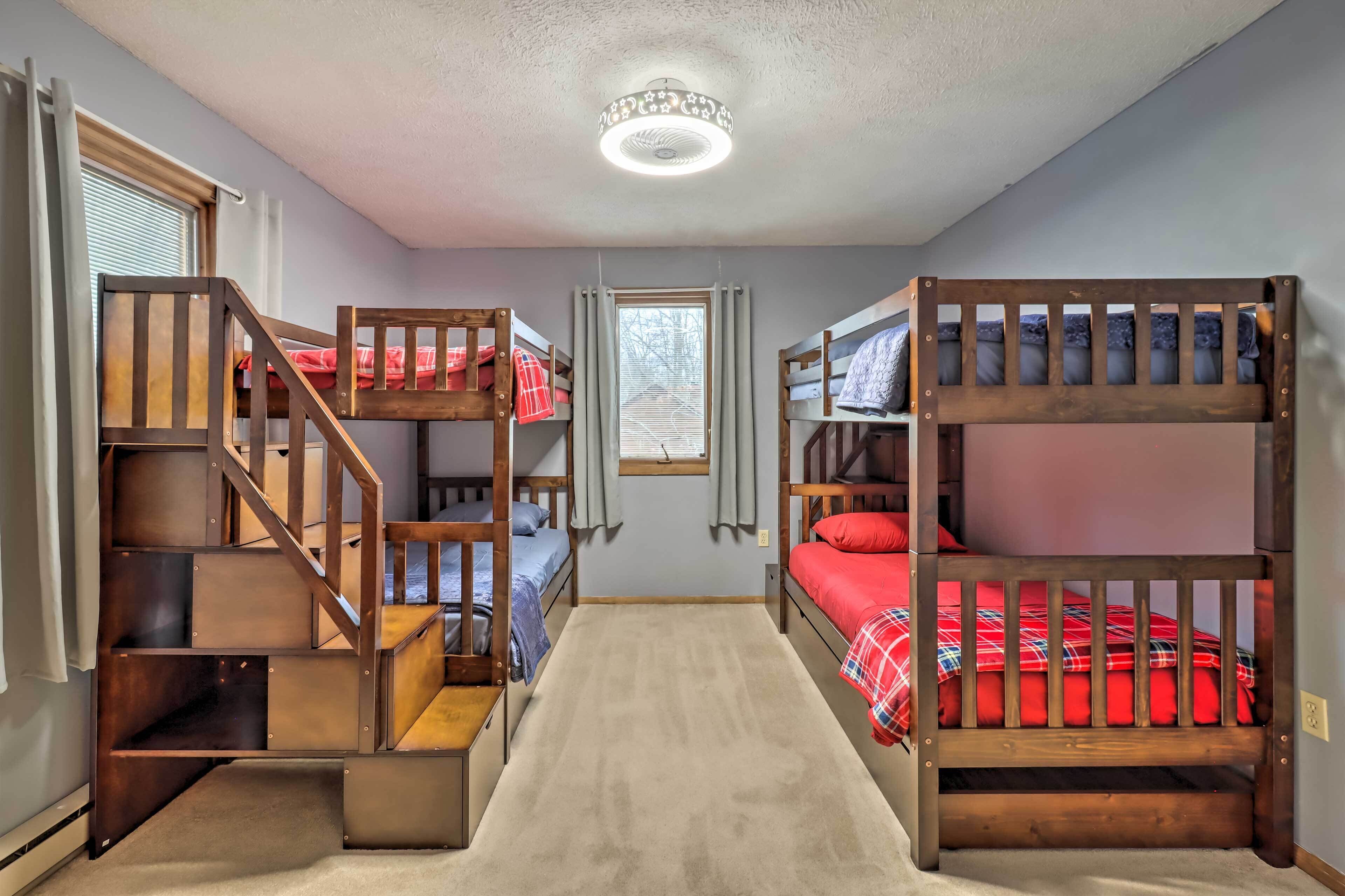 A room with bunk beds, a carpeted floor, and a window with curtains.