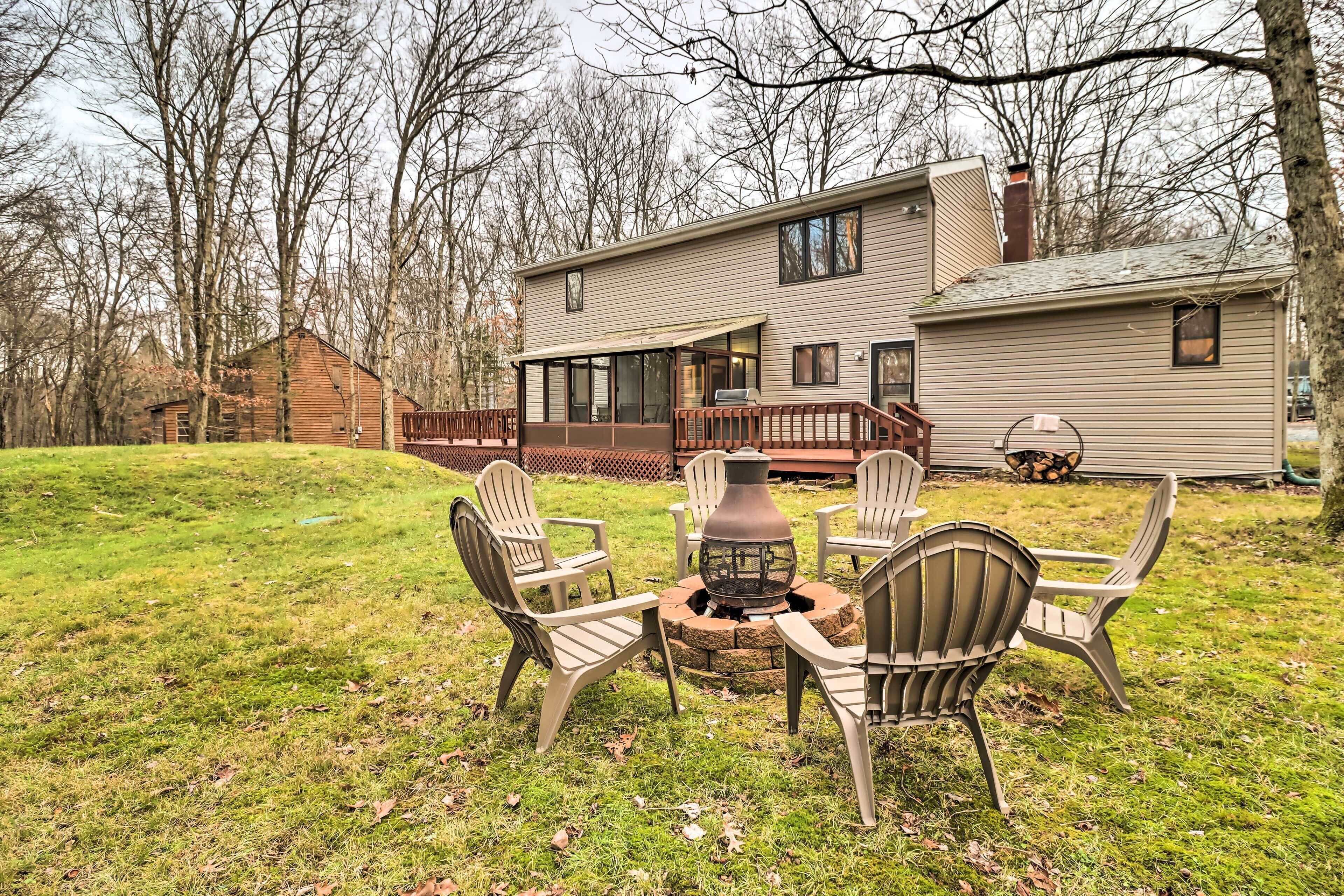 A house with a deck, a fire pit, and outdoor seating.