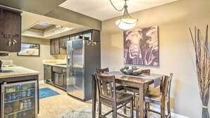 A modern kitchen with a refrigerator, a dining table with chairs, and a painting on the wall. - Peoria Oasis w/ Resort Amenities, 2 Mi to Downtown (Peoria)