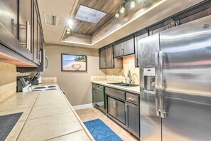 A modern kitchen with stainless steel appliances, a built-in oven, and a large island with a black rug.
