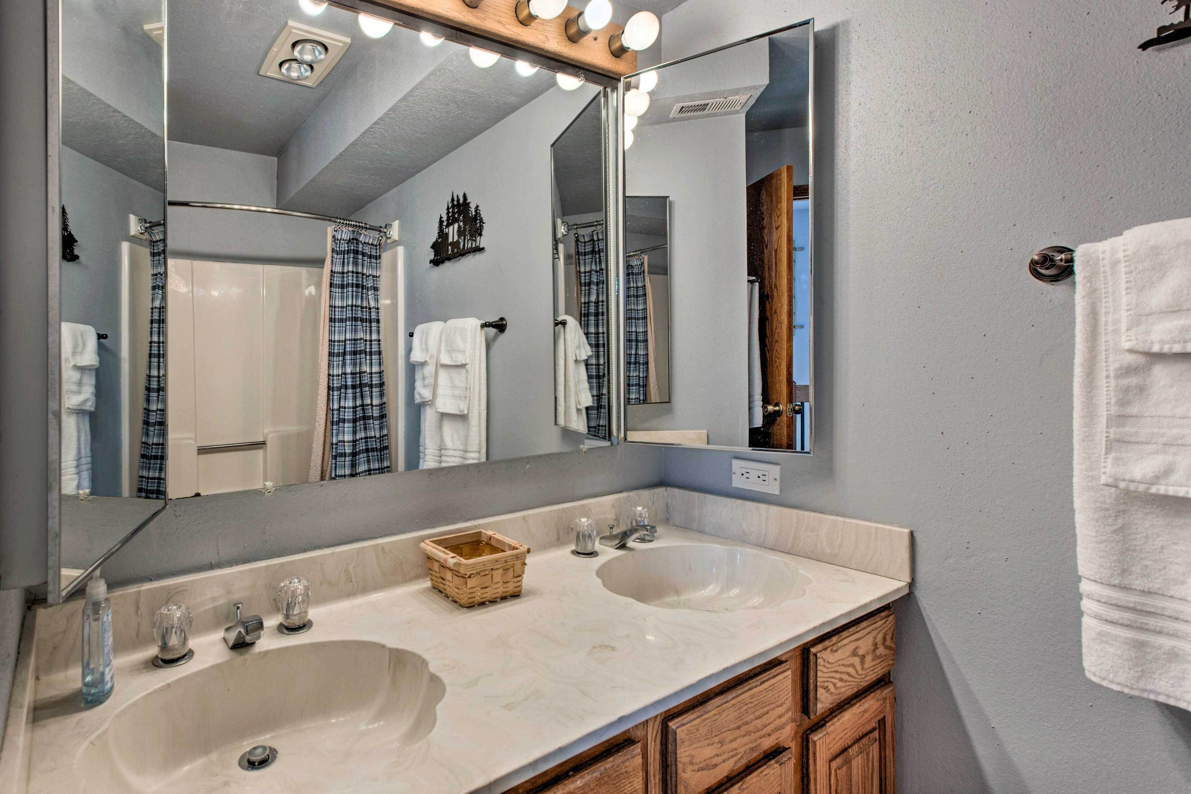 Une salle de bain avec deux lavabos, un grand miroir et un meuble en bois.