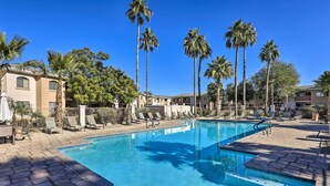 A swimming pool with lounge chairs and palm trees. - Dog-friendly Condo w/ Pool & Hot Tub in Phoenix (Phoenix)