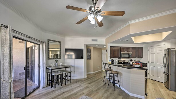 A modern kitchen with a central island, a dining area with a table and chairs, and a ceiling fan. - Dog-friendly Condo w/ Pool & Hot Tub in Phoenix (Phoenix)