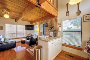 Un espacio de sala acogedor con chimenea, una estación de café y un área de descanso confortable.
