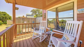 A wooden deck with two rocking chairs and a table, overlooking a fenced yard. - Pet-friendly Fredericksburg Cabin w/ Hot Tub! (Fredericksburg)