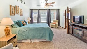 A bedroom with a bed, a ceiling fan, a TV, a chair, and a dresser. - Patio, Grill & Fire Pit: Show Low Escape! (Show Low)