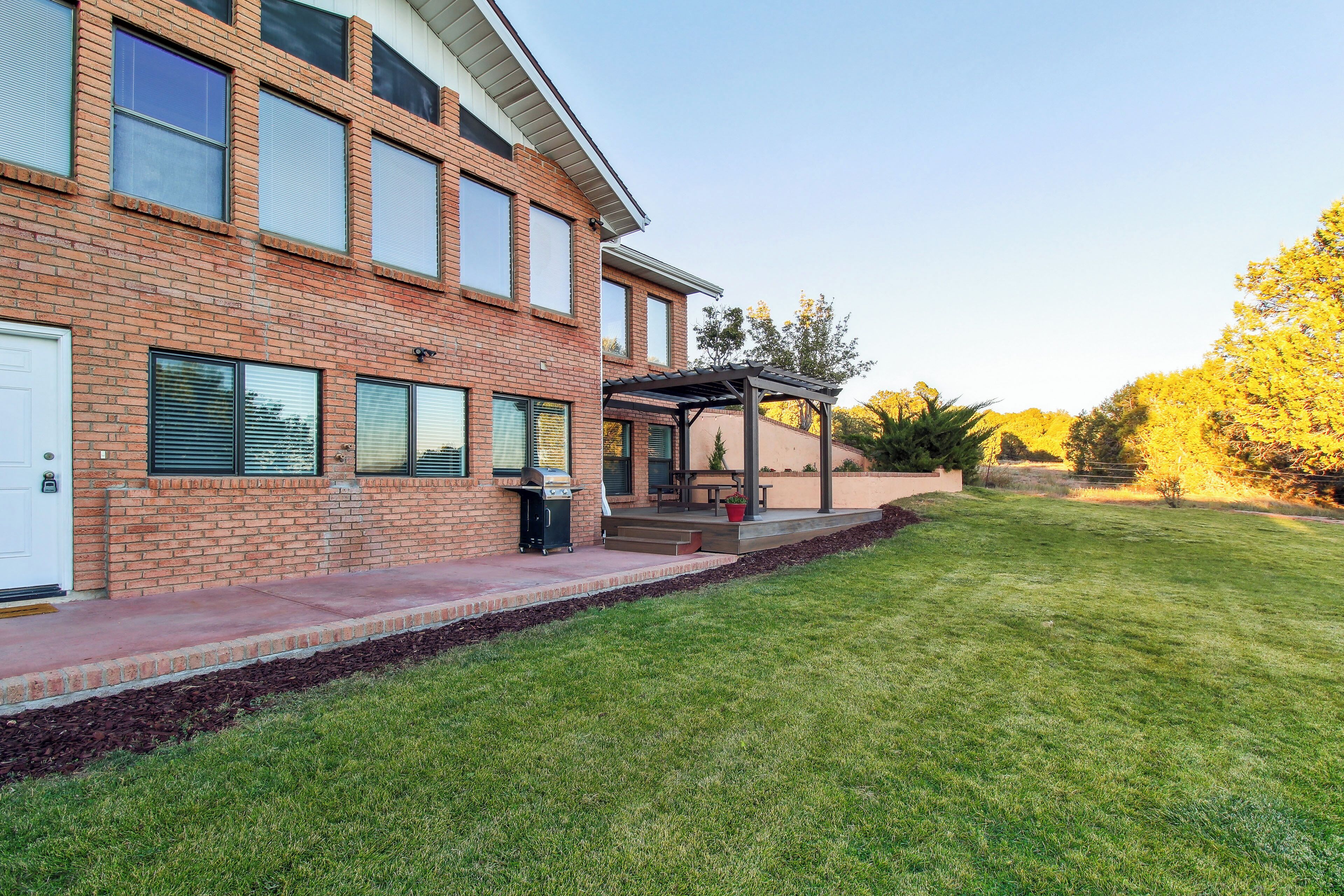 A two-story brick building with a covered patio area and a well-maintained lawn.