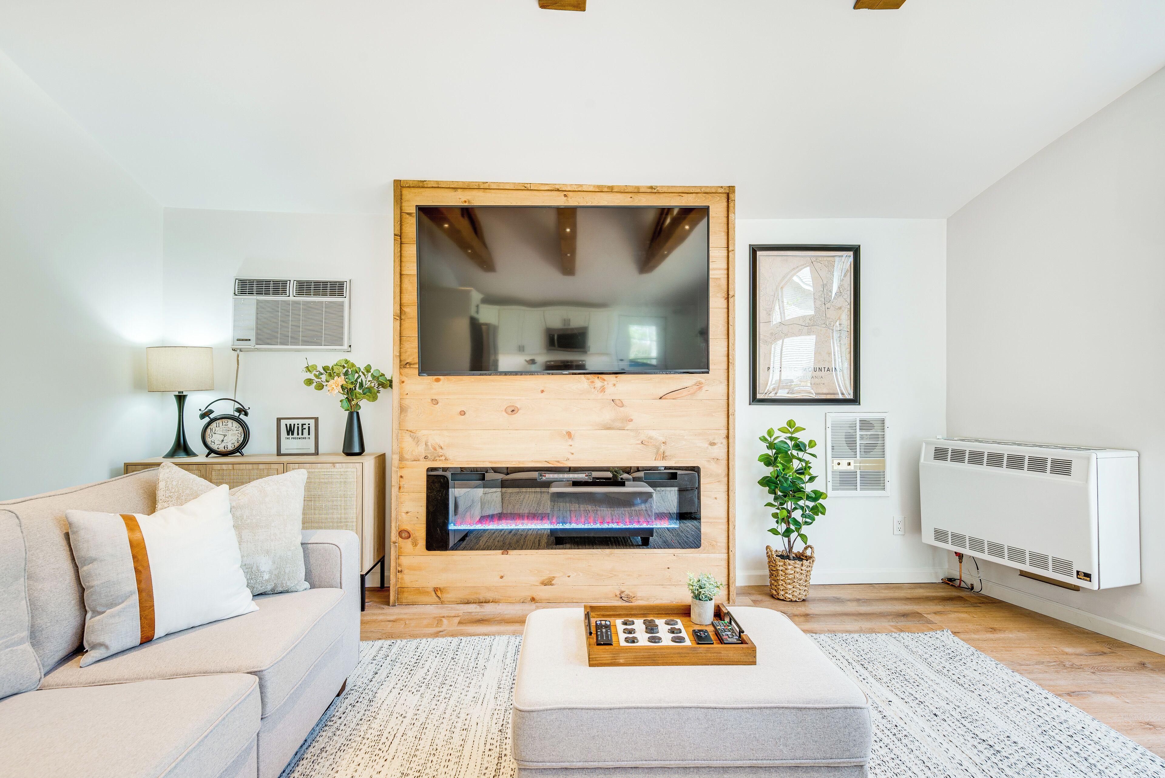 Una sala de estar moderna con chimenea, un sofá, una mesa de centro y una pequeña planta.
