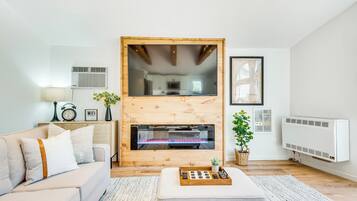 Una sala de estar moderna con chimenea, un sofá, una mesa de centro y una pequeña planta.