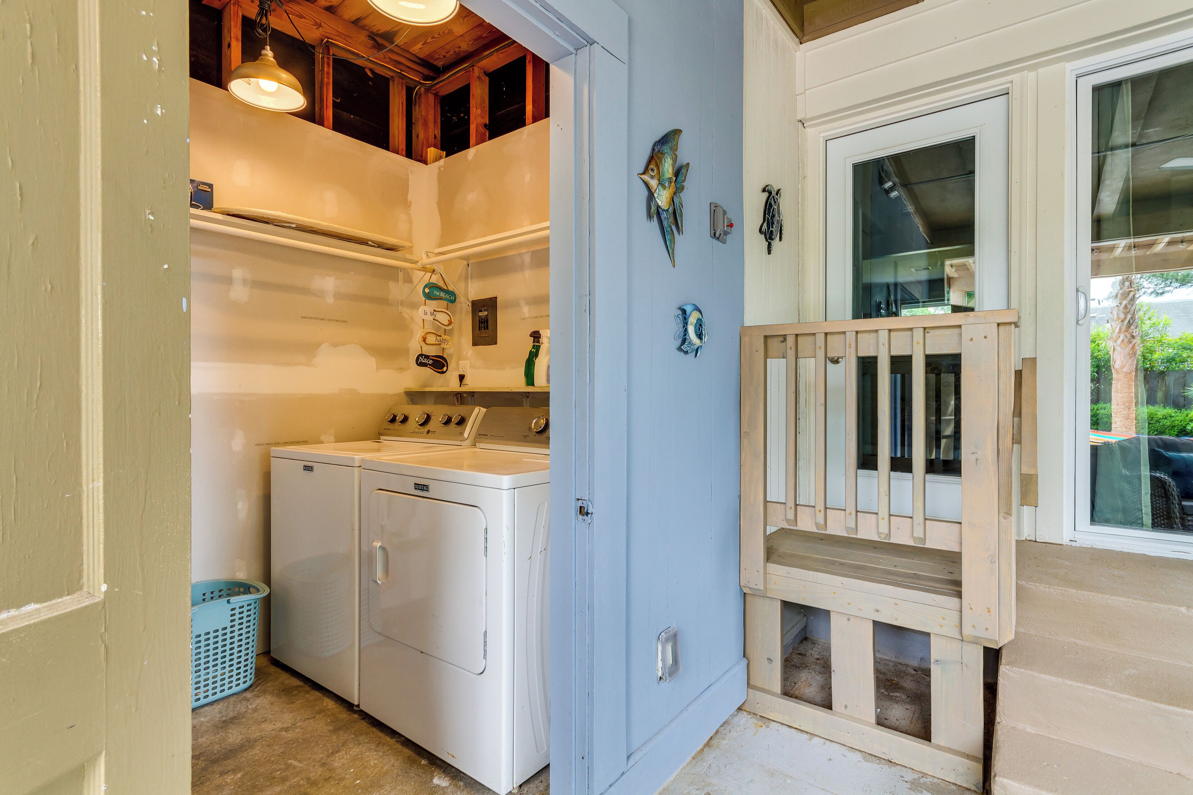A laundry room with a washing machine, dryer, and a small window.