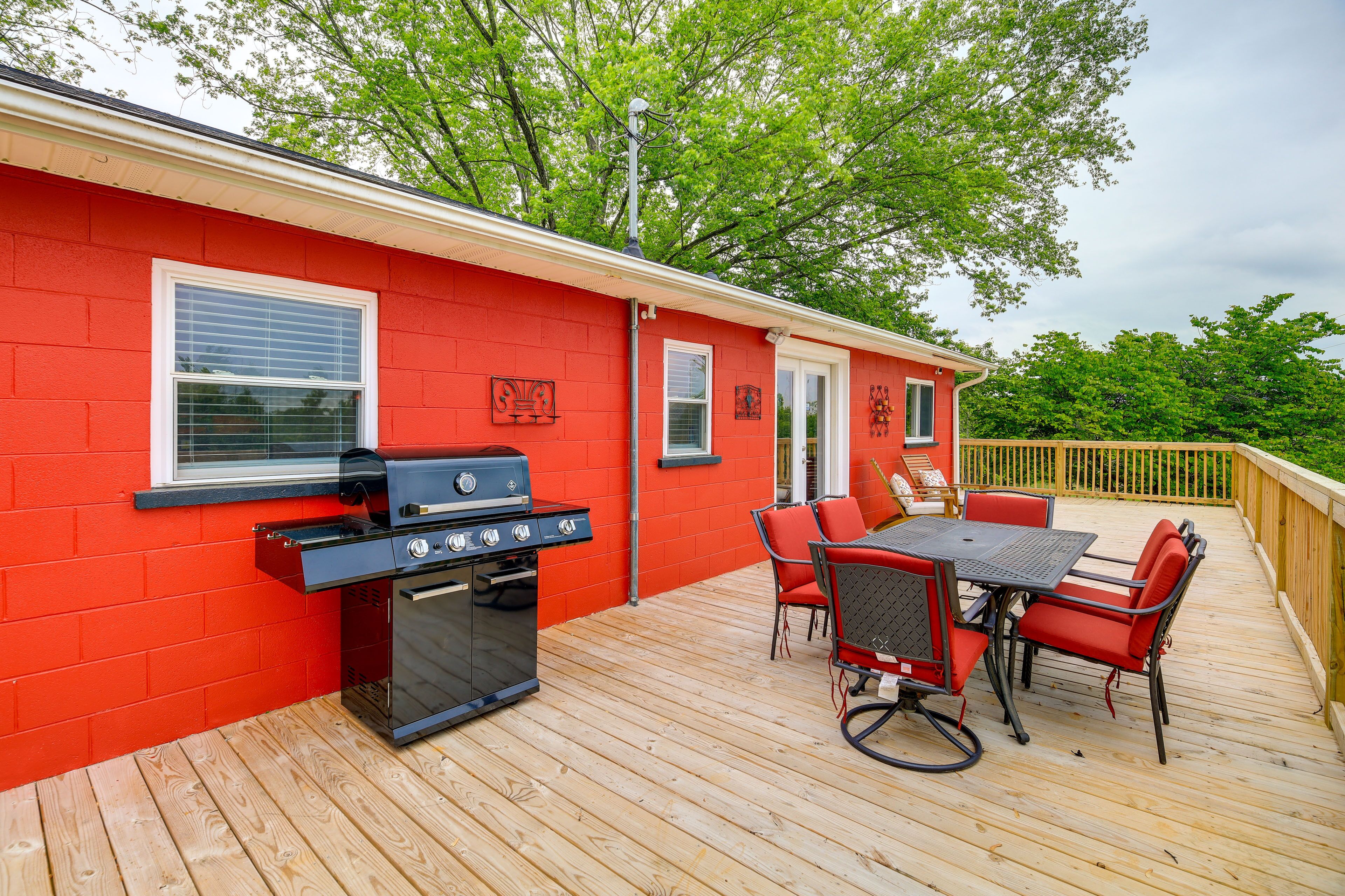 A red building with a barbecue grill and outdoor seating.