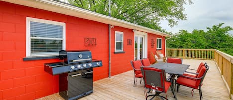 A red building with a barbecue grill and outdoor seating.