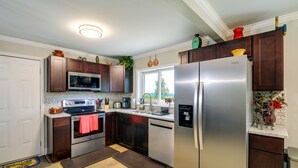 Eine moderne Küche mit Edelstahlgeräten, dunklen Holzschränken und einem großen Kühlschrank.