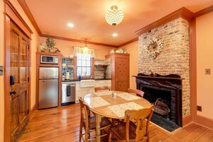 Una cocina acogedora con chimenea, armarios de madera y una mesa de comedor con sillas.