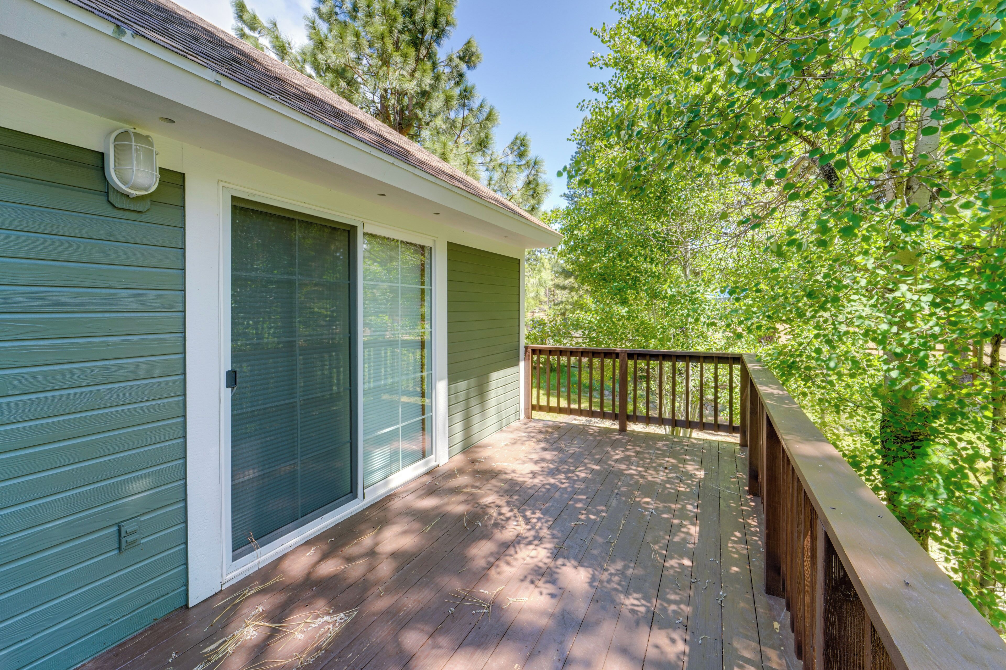 A single-story house with a covered porch, a sliding glass door, and a small deck area.