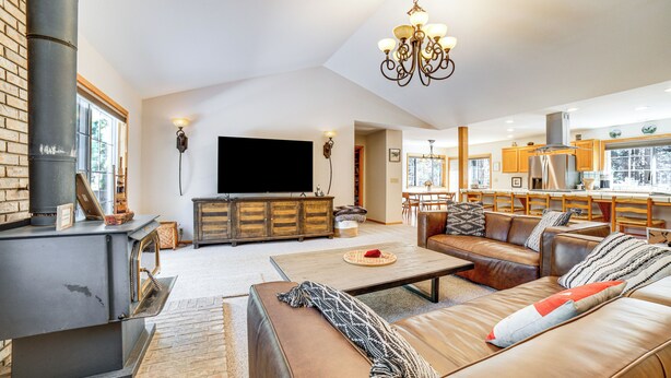 A spacious living room with a fireplace, leather sofa, and a television. - Calpine Mountain Retreat w/ High-speed Internet (Calpine)