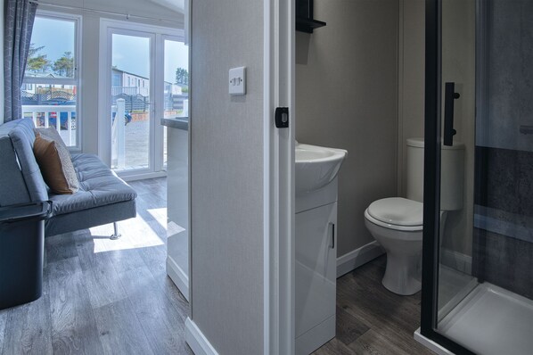 Un baño moderno con inodoro, lavamanos y ducha.