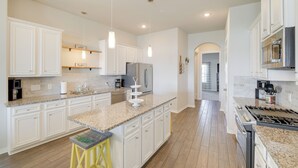 A spacious kitchen with white cabinetry, granite countertops, and stainless steel appliances. - Bay-view La Porte Home Rental: Steps to Beach! (La Porte)