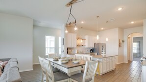 A spacious kitchen with white cabinets, a central island, and pendant lighting. - Bay-view La Porte Home Rental: Steps to Beach! (La Porte)