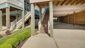 A multi-level wooden structure with a central staircase, surrounded by a concrete walkway and a small garden area. - Bay-view La Porte Home Rental: Steps to Beach! (La Porte)