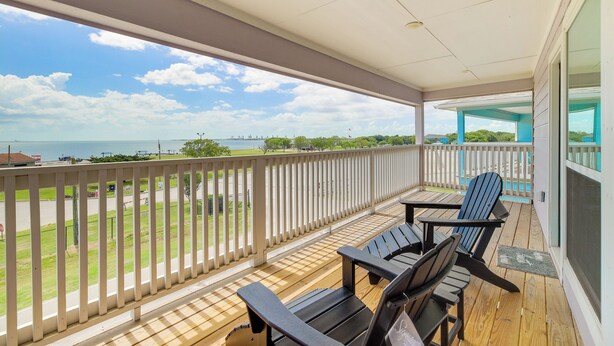 A wooden deck with two Adirondack chairs and a view of the ocean. - Bay-view La Porte Home Rental: Steps to Beach! (La Porte)