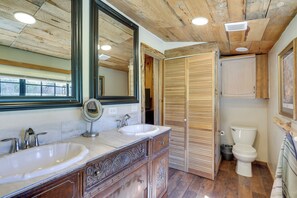 A bathroom with wooden flooring, a double sink vanity, a toilet, and a wooden door. - 9 Mi to Bass Lake: Cabin w/ Fire Pit in Wishon! (Wishon)