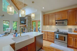 Una cocina moderna con armarios de madera, un horno de acero inoxidable y una isla grande con un lavamanos.