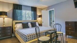 A neatly arranged bedroom with a bed, bedside tables, a chair, and a desk. - Private Pool & Patio: Fort Lauderdale Home! (Fort Lauderdale)