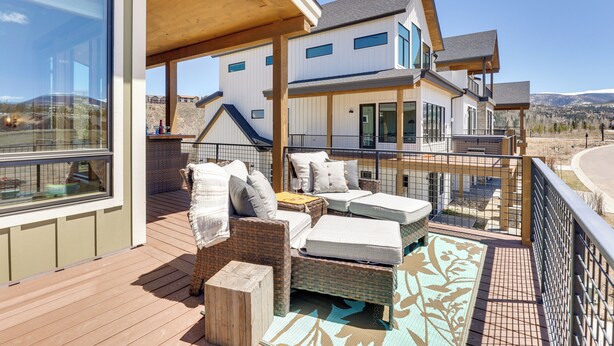 A modern house with a wooden deck, outdoor seating, and large windows overlooking a scenic landscape. - Fraser Getaway w/ Deck Near Winter Park Resort! (Fraser)