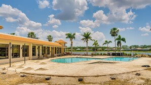 A swimming pool area with a building adjacent to it. - North Fort Myers Getaway w/ Resort Amenities! (North Fort Myers)